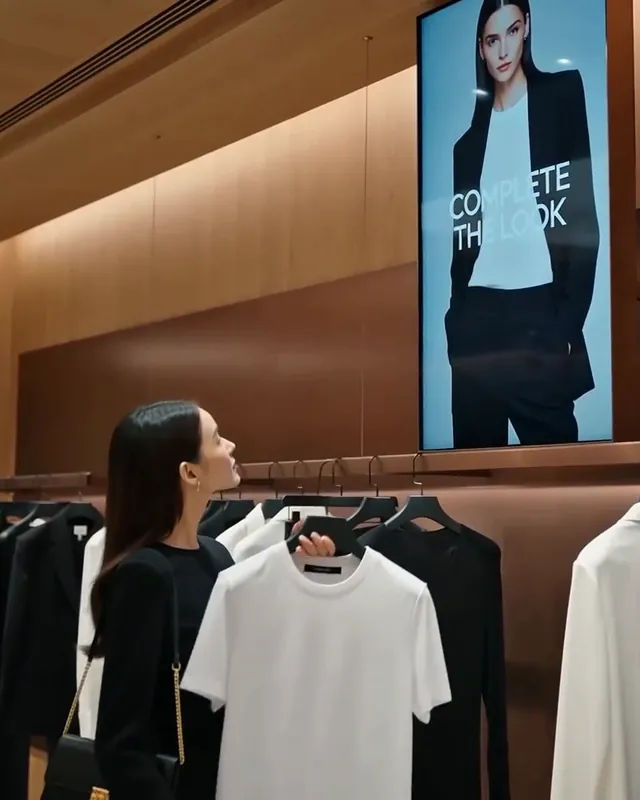 Müşteri beyaz tişörtü önünde tutuyor