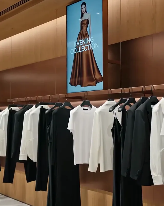 Karanlık bir butikte askıda dokunulmamış beyaz bir tişört